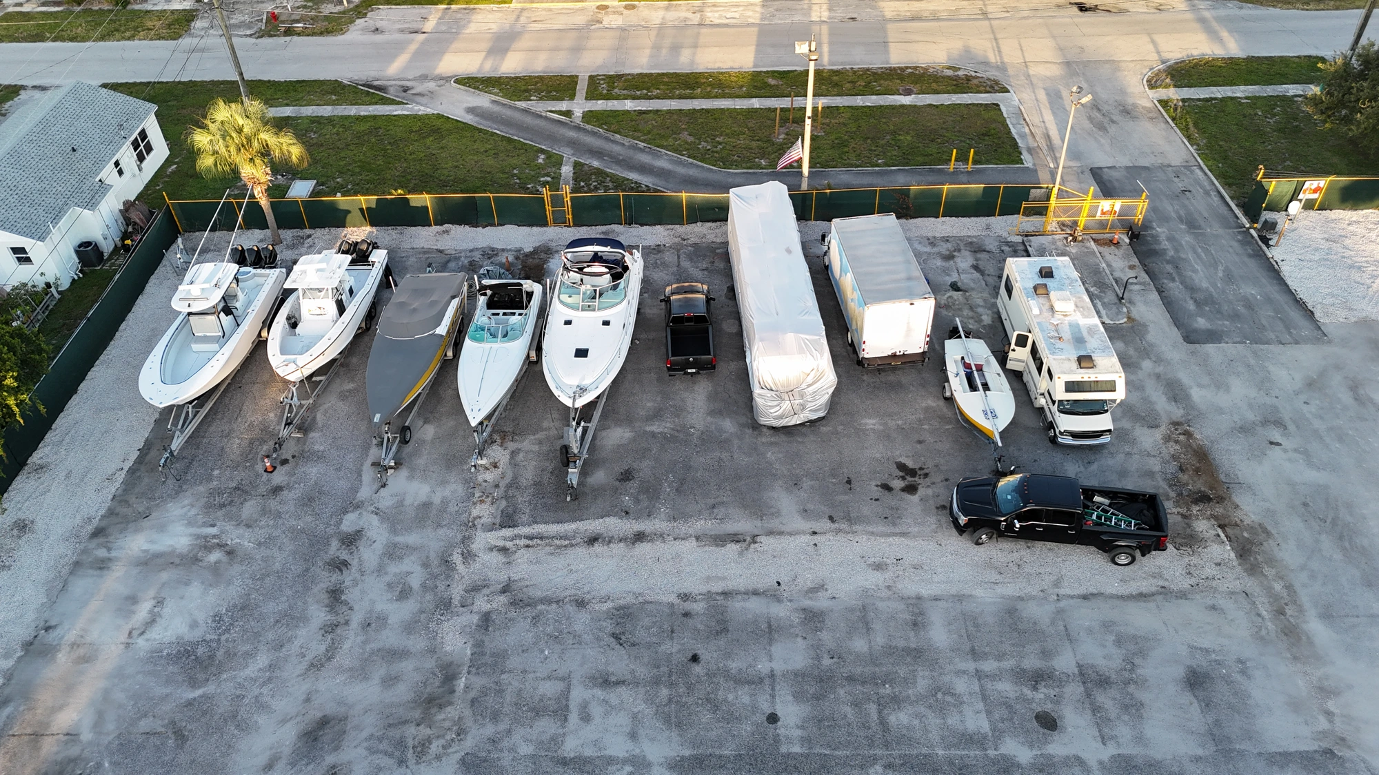 Boats, box truck and trailer in a parking row near the gate