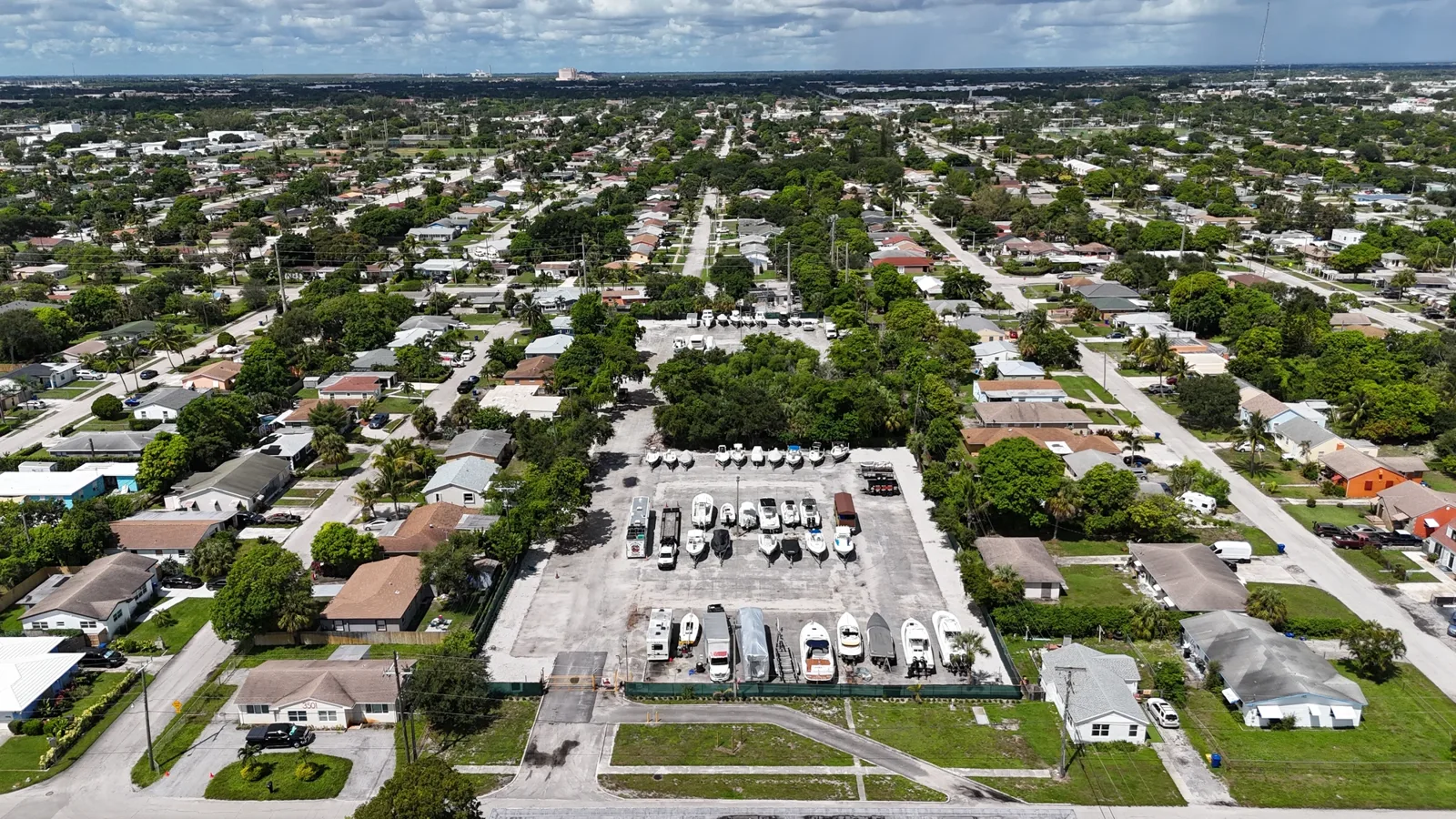 High aerial of the fenced Riviera Beach parking lot and neighborhood