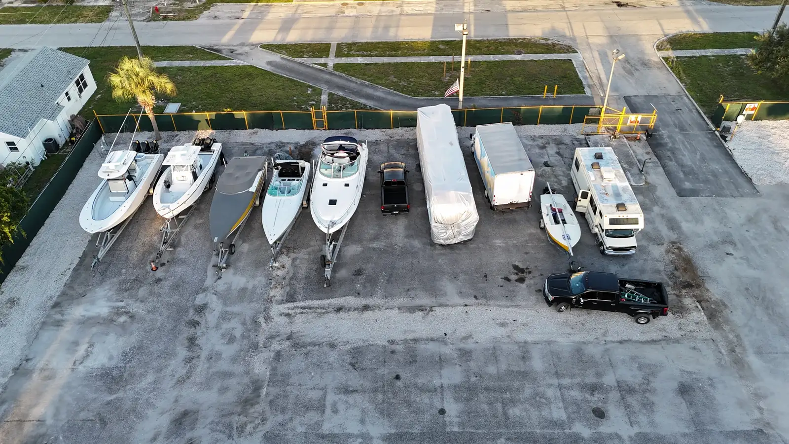 Boats, box truck and trailer in a parking row near the gate
